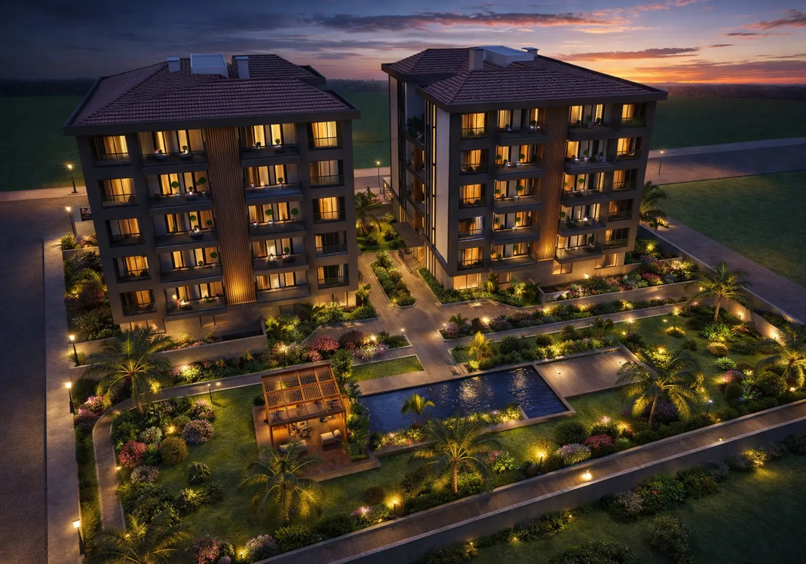 Havadan akşam görünümü: iki blok, havuz, pergola ve aydınlatılmış peyzaj alanları